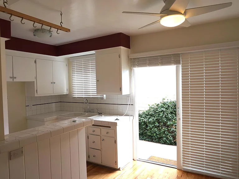 Newly tiled kitchen with stove and large sliding glass doors