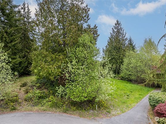 A view of the lot from the street. Your driveway would start at the white marker. There is a neighborhood trail and short easement between the lot and the paved trail. Peaceful neighbors and polite walkers on this cul-de-sac and North Bay trails>