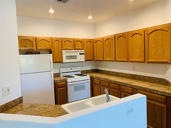 Open kitchen with granite countertops and ample cabinet storage