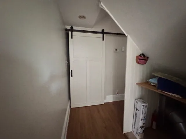 Around the corner from second bedroom is another barn door covering the brand new large capacity stacked washer/dryer.