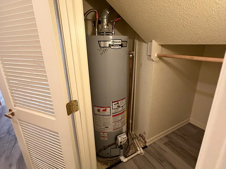 Under stair closet with gas water heater.