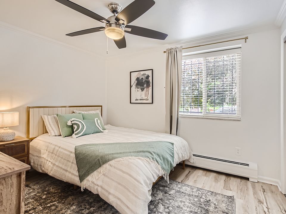 The primary bedroom features a brand-new queen size mattress with soft sheets and pillows, a nightstand and reading lamp, a ceiling fan, blackout curtains, and a dresser plus a large closet for storing all of your clothes and gear.