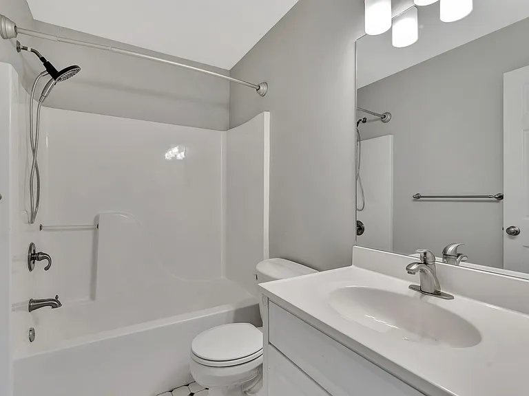 Full bath (shared - Bedroom 1 and 2) with a tub/shower combo, large vanity and mirror.