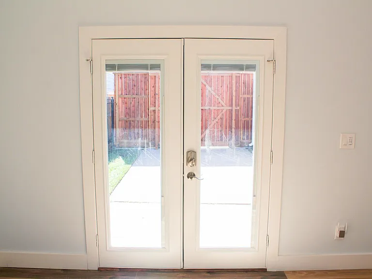 View with blinds open and private shared courtyard in gated area.