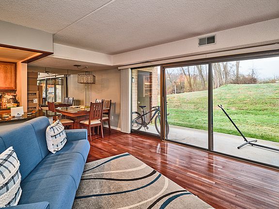 Open concept living, dining, and kitchen w/ hardwood floors & sliding glass doors to covered patio.