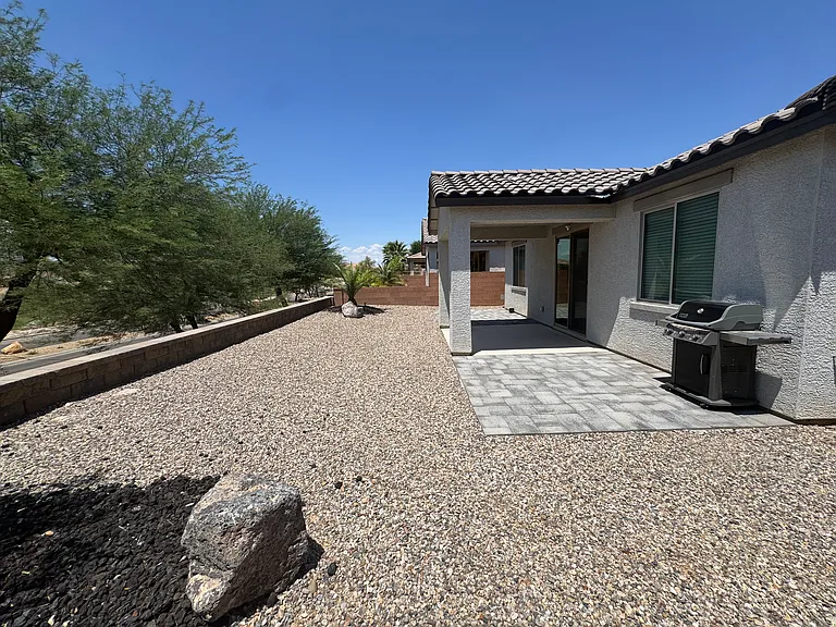 Spacious, low-maintenance backyard with a covered patio and paved seating area