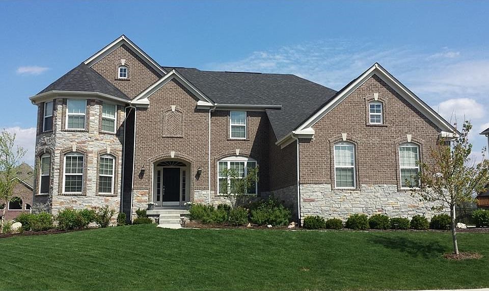 Light and dark gray stone and brick exterior with a stone turret.