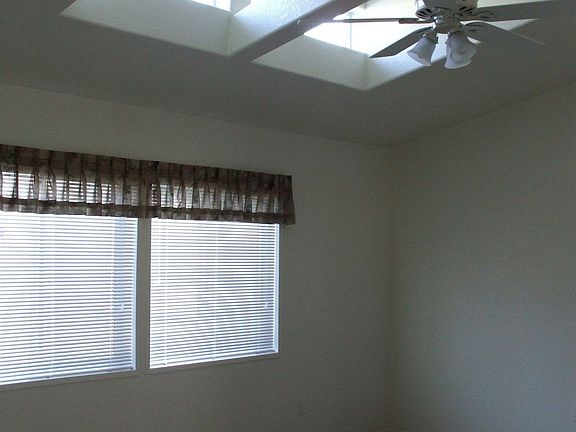 Living room w/ special windows and ceiling fan