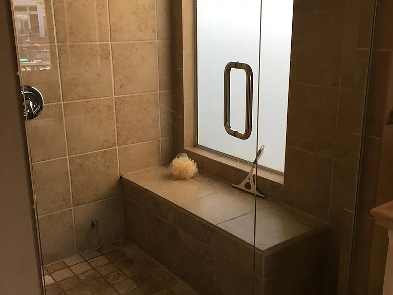 Walk-in fully tiled master shower with bench and privacy window