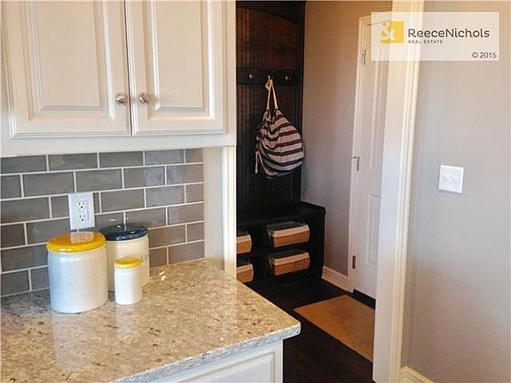 Wood boot bench and hooks through garage entry.