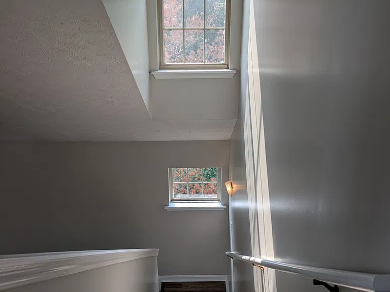 Stairwell landing filled with natural sunlight from multi-level windows