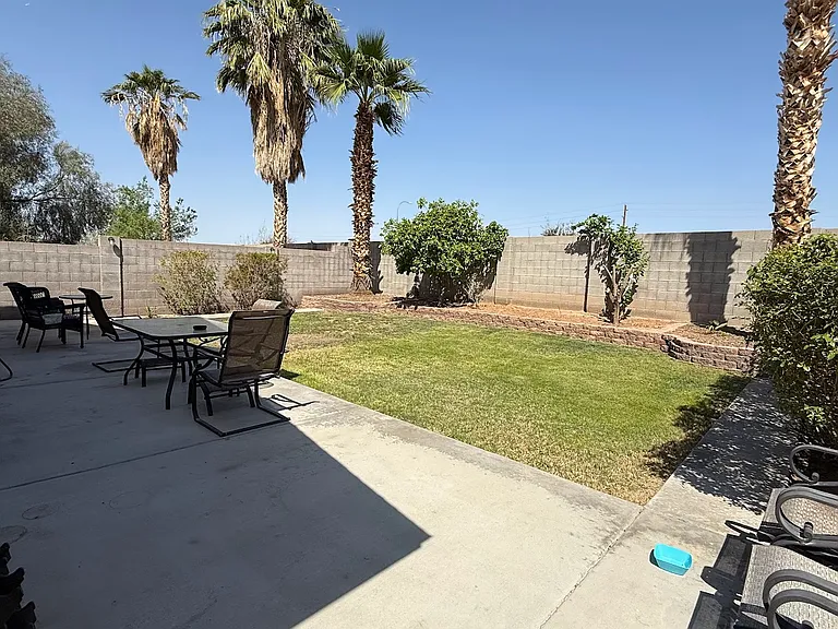 The backyard is visible from the sliding glass door and is lush and green. Plenty of space for entertaining as well as for children to play