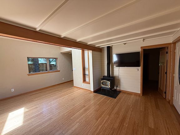 Living room looking at gas fire place with door to den/bedroom/bathroom on right.