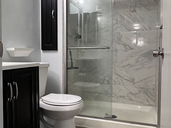 Master bathroom with upgrades including porcelain tile shower, double sliding glass door, upgraded medicine and storage closets and fixtures