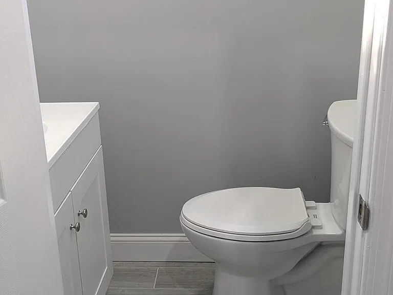 Compact half-bath with a vanity for storage and durable tile flooring, convenient for guests and everyday use.