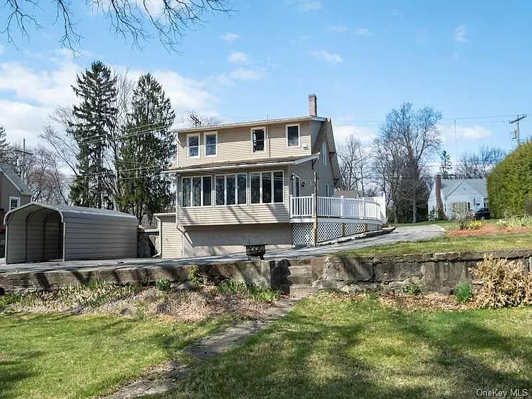 Sunroom, deck, and carport. Parking for multiple vehicles. (wall in photo no longer exists)