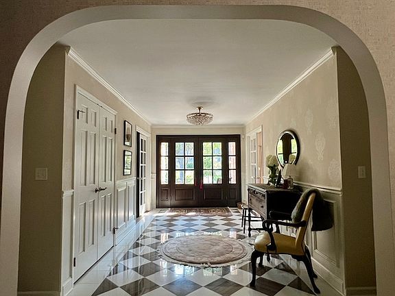 Foyer viewed from the living room. Hall Closet is shown on left side. To the right is the dining rm and to the left is the library.