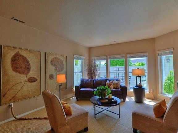 Wall of windows surrounds formal living room. Looks out to private courtyard.