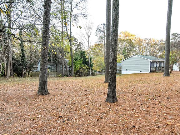 Spacious backyard with trees.