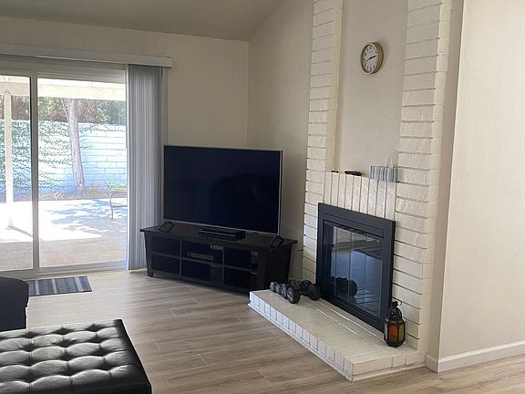 Living room features high vaulted ceilings and wood flooring.