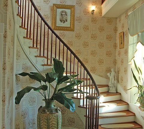 View of winding staircase, upper right is a widows walkway.