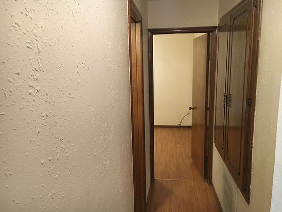 hallway with main bathroom on left. West bedroom at end of hall way. The hot water closet and heat and air closet to the right.