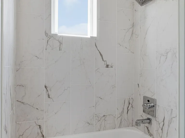 Guest bathroom with tiled walls around the bathtub as well as tile floor