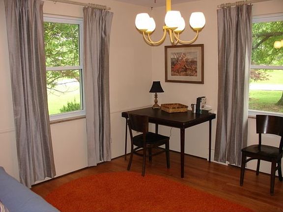First floor bedroom has hardwood floors and a vintage chandelier