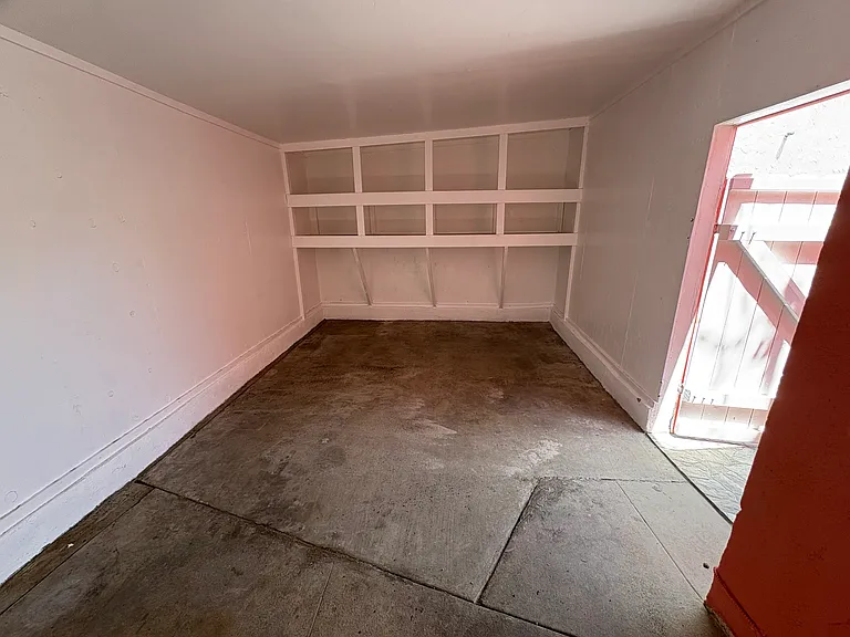 Freshly painted, covered carport with new storage shelves. Additional parking space behind if needed.