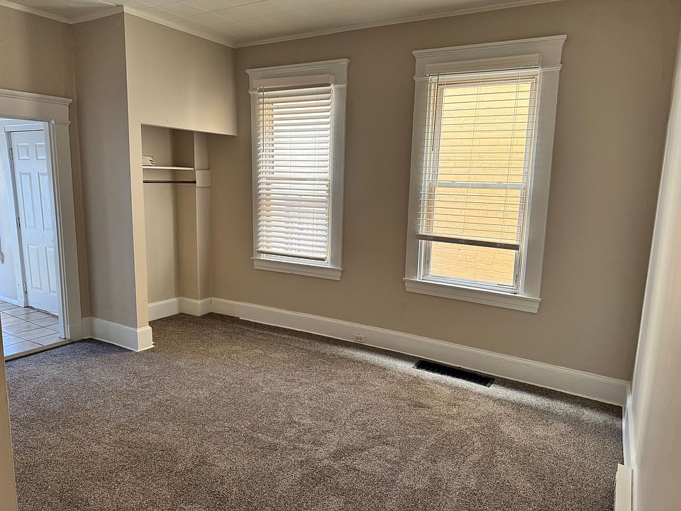 Entering the bedroom from the front room. Huge windows, with new shades.