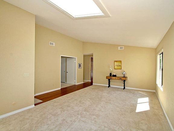 Formal living/dining area has sloping ceiling and opening skylight .