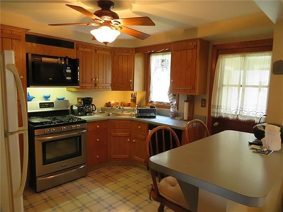 Custom cabinets, breakfast bar, new stove and access to the 3 season room and the beautiful backyard.