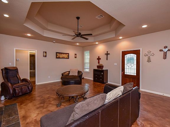 Spacious living room with a conferred ceiling, stained concrete floors and slate tile fireplace.