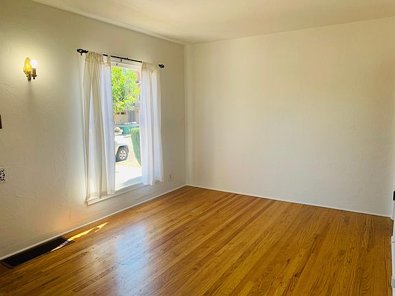 large picture window , vintage sconce and gorgeous oak floors