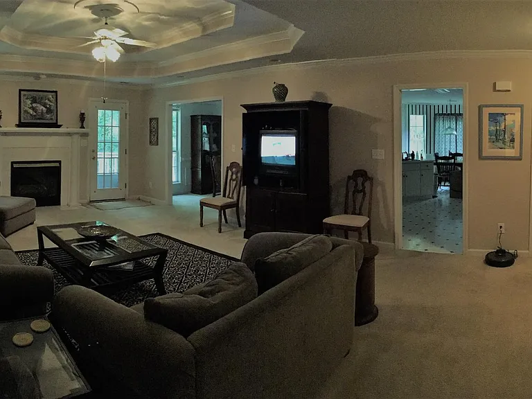 Living room showing entrances to deck, kitchen & dining room