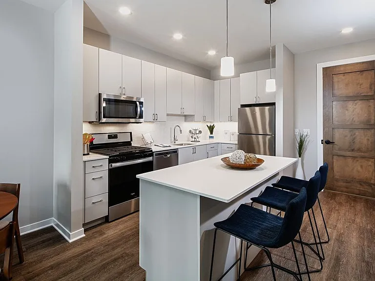 Base Scheme apartment home kitchen with light grey cabinetry, stainless steel appliances, and hard surface flooring