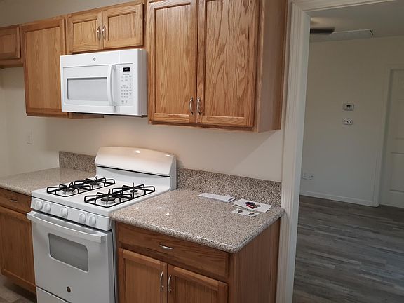 Kitchen-New gas range with over-stove microwave, view into living room