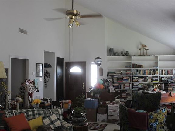 Another view of large living room. Book shelves. High Ceilings. Seller working on packing up their stuff!.
