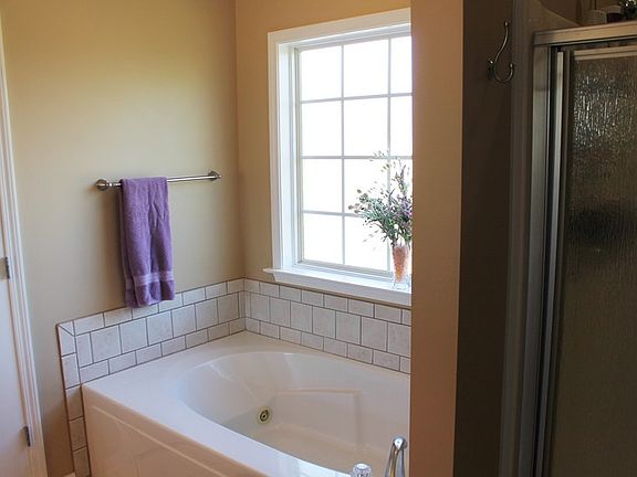 The ensuite bathroom connects the master bedroom to a large walk-in closet.