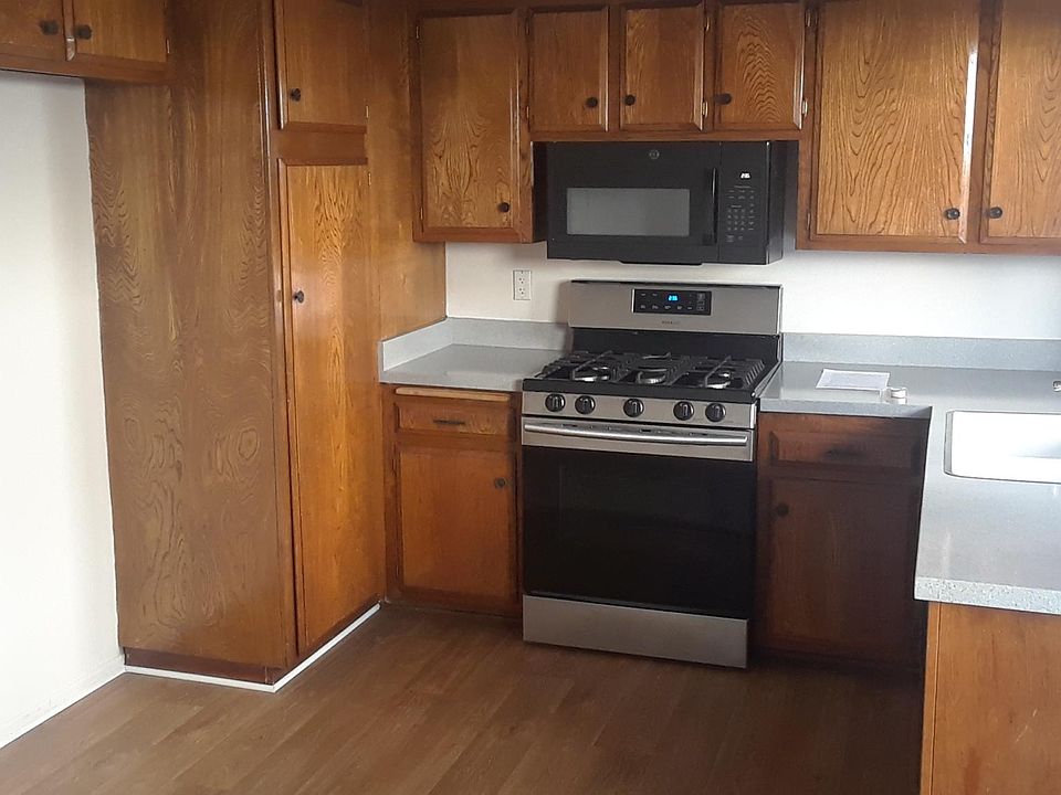 Kitchen_range/microwave/floor. Big window over sink facing private patio.