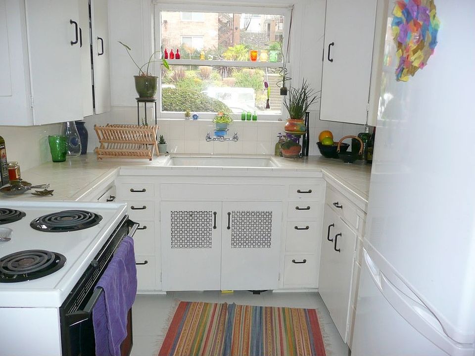 Kitchen has tile counters and picture window