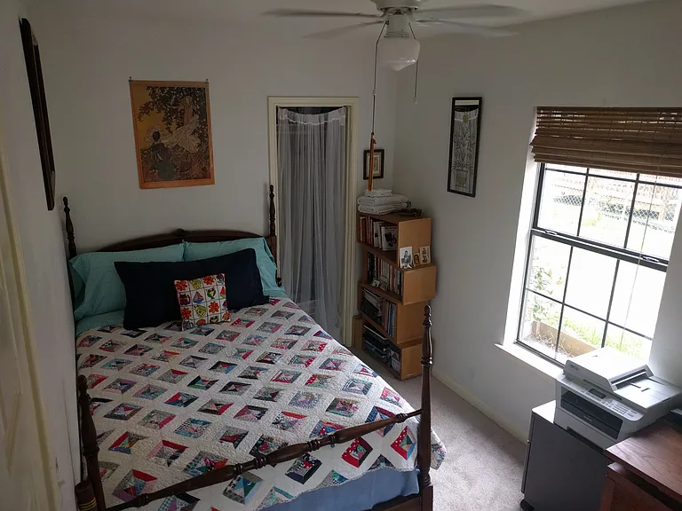 Examples of furnished front room as bedroom with full-sized bed and workspace
