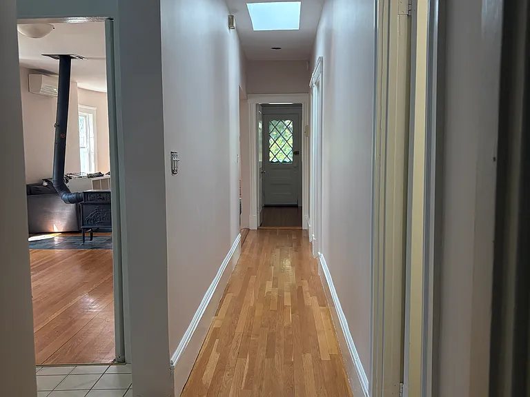 Hallway runs through entire apartment separating common areas from bedrooms. Two huge bright skylights.