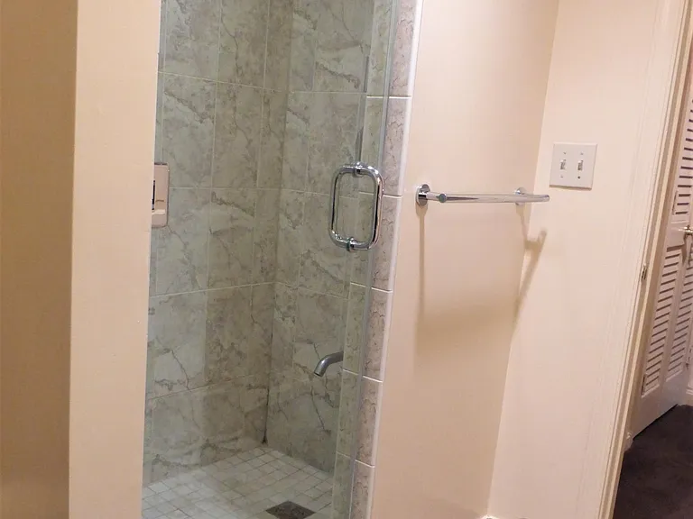 The bath includes a walk-in shower with stylish tiles