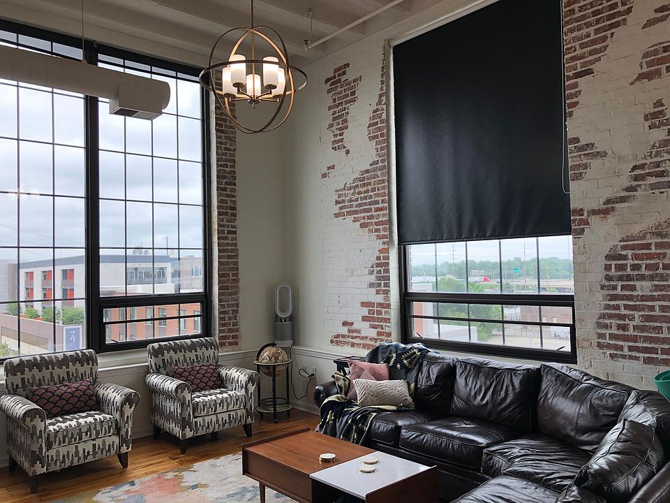 Living room area - beautiful exposed brick, brass chandelier stays with condo, plenty of room for a wrap-around couch (brown leather couch in photo available upon request). All windows come with blinds that can be rolled down or up.