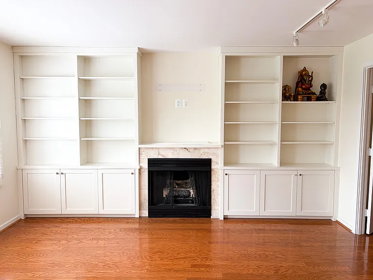 Living room fire place and built-in shelves and TV mounting area.