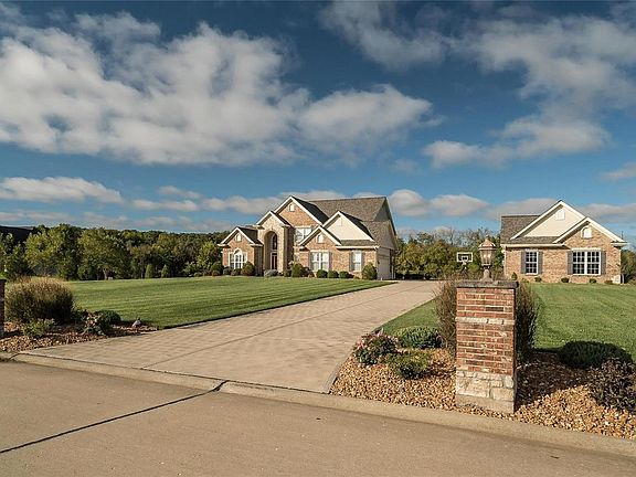 Stately Entrance to this beautiful custom built home, Brick Pillars with Coach Lighting and Professional Landscaping-Detached Garage with garage door and opener with service door.