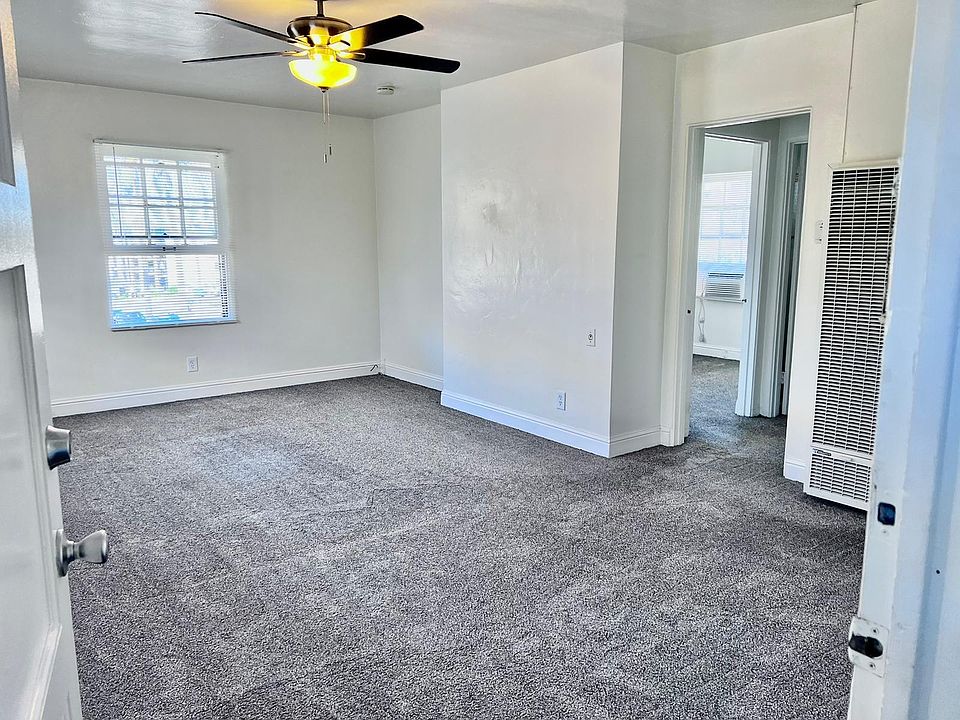 Living-room with wall heater and ceiling fan.