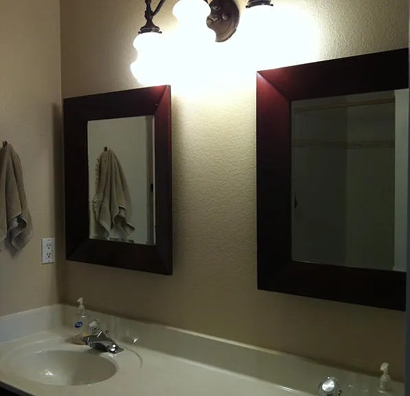 Primary bath with double vanity and mirrors across from large oval garden tub and shower.