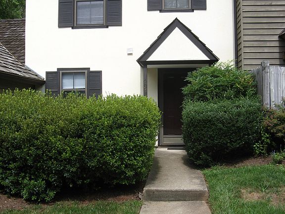 sitting patio behind tall azalea bushes to the left
